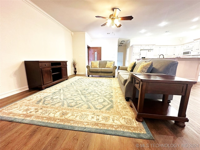 living room with dark hardwood / wood-style flooring, ornamental molding, and ceiling fan