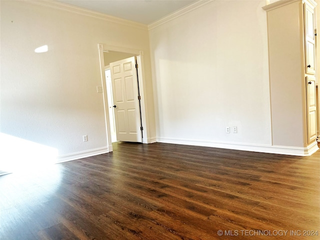 empty room featuring dark hardwood / wood-style flooring and crown molding