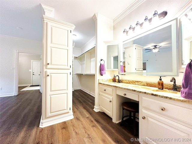 bathroom featuring ceiling fan, ornamental molding, wood-type flooring, and vanity