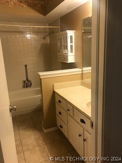 bathroom with tile patterned flooring, vanity, and tiled shower / bath combo