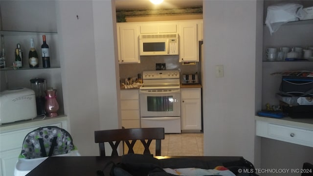 kitchen with white cabinets, white appliances, and light tile patterned floors