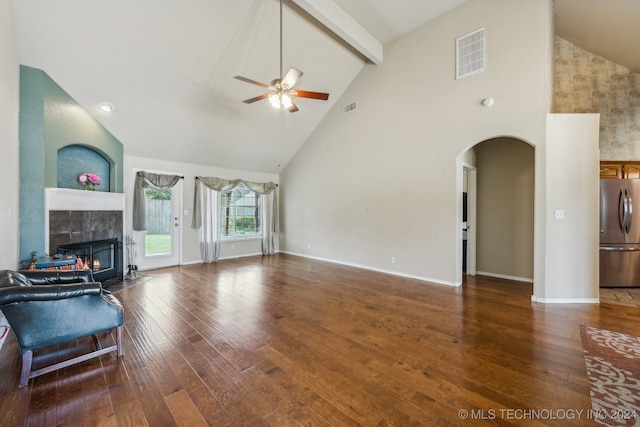 unfurnished living room with a tiled fireplace, beam ceiling, hardwood / wood-style floors, high vaulted ceiling, and ceiling fan