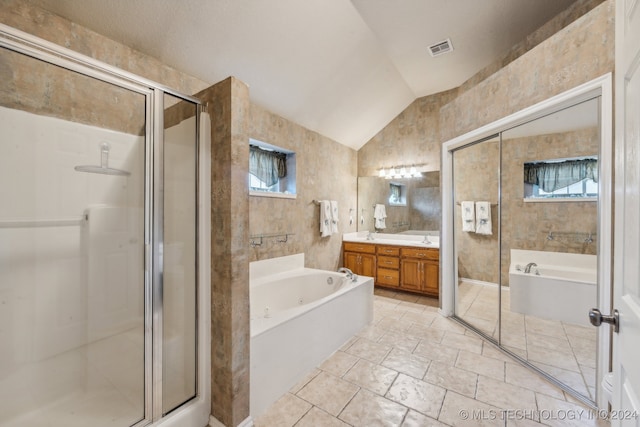 bathroom with vanity, shower with separate bathtub, vaulted ceiling, and a wealth of natural light