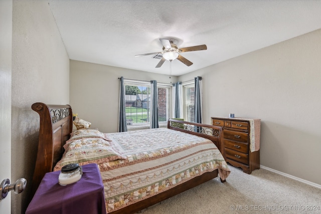 carpeted bedroom featuring a textured ceiling and ceiling fan