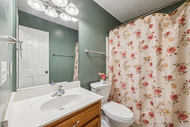 bathroom featuring toilet, walk in shower, and vanity