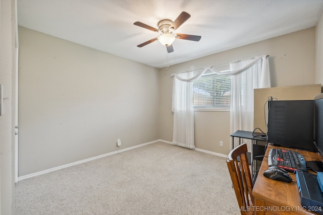 carpeted home office featuring a textured ceiling and ceiling fan