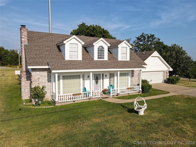 new england style home featuring a garage, a front lawn, and covered porch