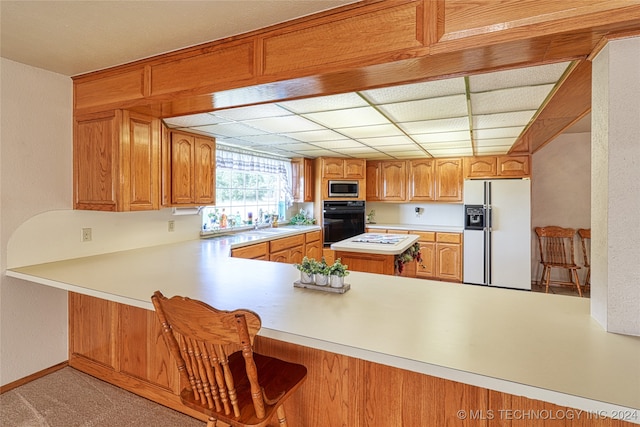 kitchen featuring white appliances, kitchen peninsula, and sink