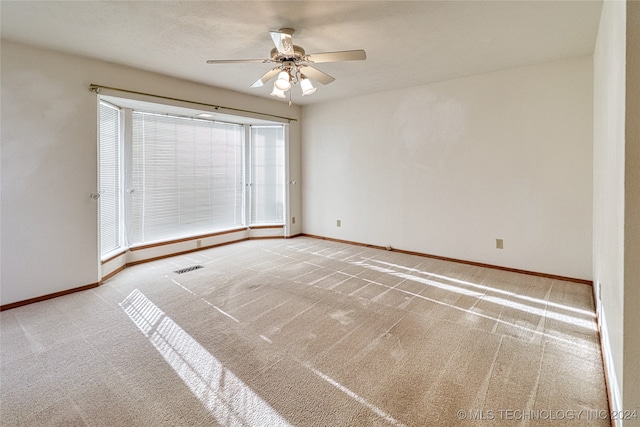 carpeted empty room featuring ceiling fan