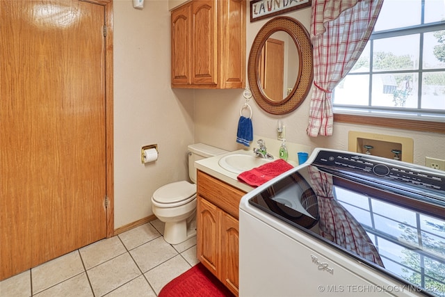 bathroom featuring tile patterned flooring, a wealth of natural light, washer / dryer, and toilet