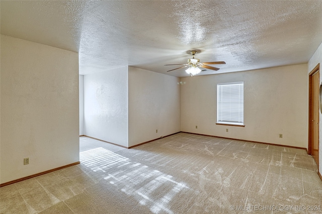 carpeted spare room with ceiling fan and a textured ceiling