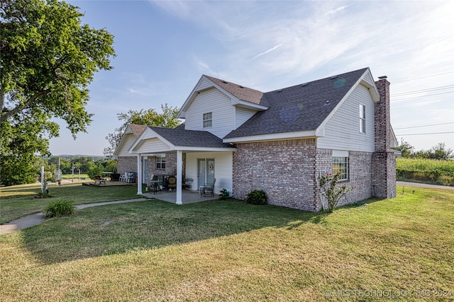 back of property featuring a lawn and a patio