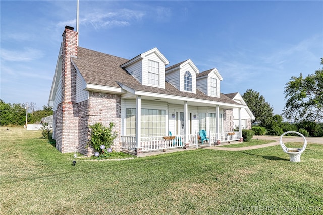 cape cod home with a front yard and a porch