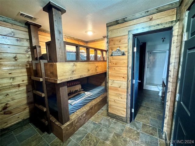 tiled bedroom with wood walls and a textured ceiling