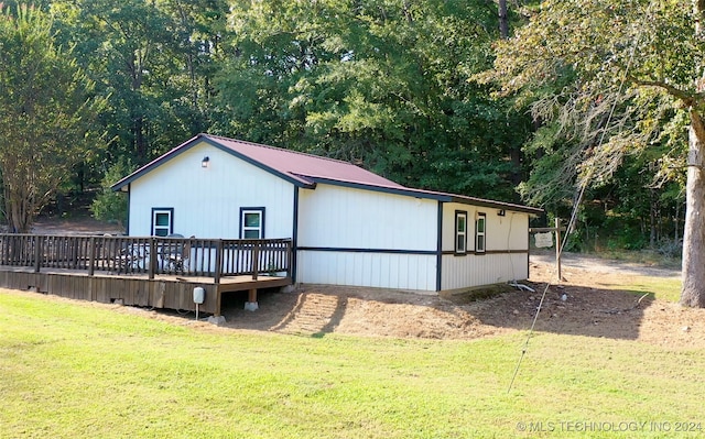 back of property featuring a yard and a deck