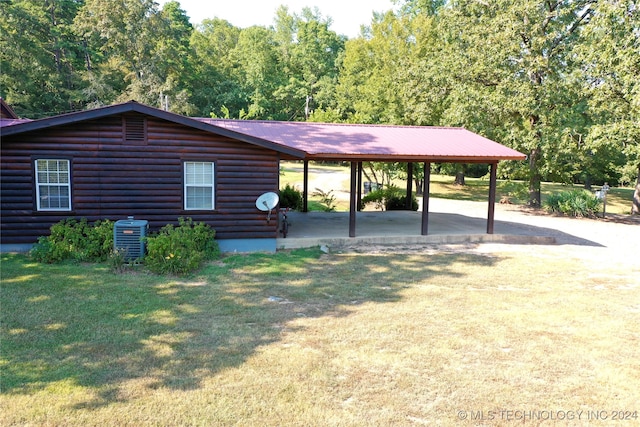 view of front of property with a carport, central AC, and a front lawn