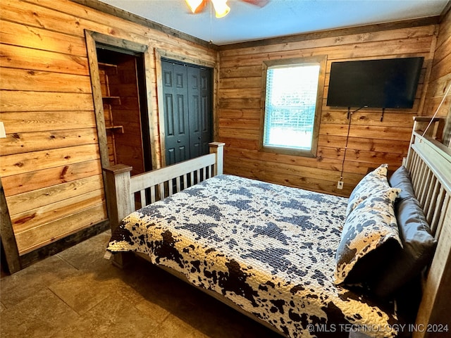 bedroom with wood walls, tile patterned flooring, and ceiling fan