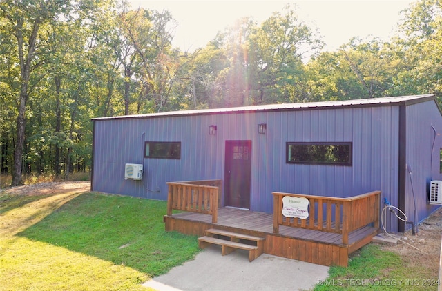 view of front of property with a front yard, a wall mounted air conditioner, and a wooden deck