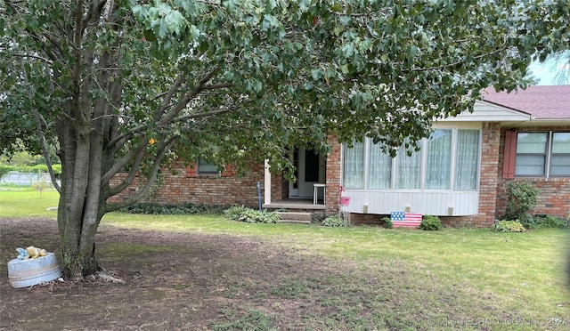 view of property hidden behind natural elements with a front lawn