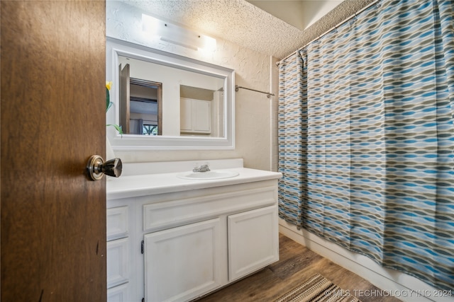 bathroom featuring curtained shower, hardwood / wood-style flooring, a textured ceiling, and vanity