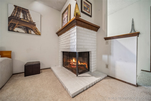 living room with light colored carpet, a fireplace, and a textured ceiling