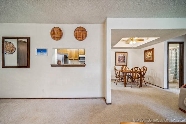 interior space with ceiling fan, light colored carpet, and a textured ceiling