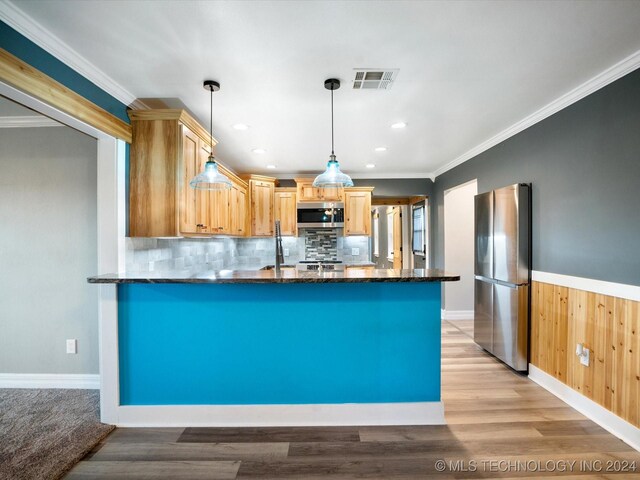 kitchen with wood walls, light hardwood / wood-style flooring, light brown cabinetry, appliances with stainless steel finishes, and decorative light fixtures