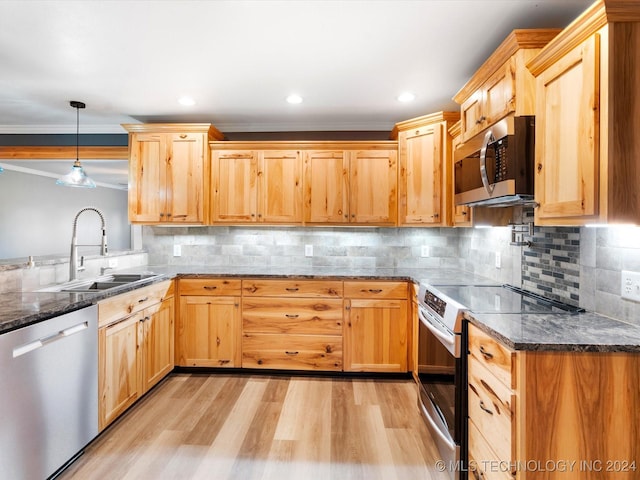 kitchen with light hardwood / wood-style flooring, ornamental molding, appliances with stainless steel finishes, tasteful backsplash, and decorative light fixtures