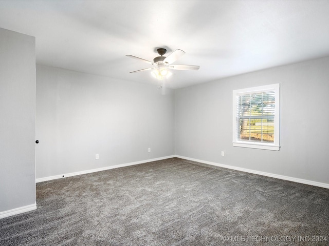 empty room with ceiling fan and dark carpet