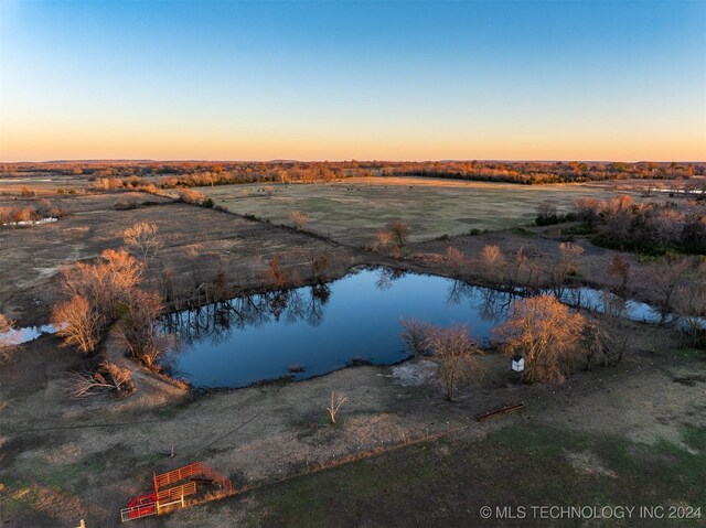 aerial view at dusk featuring a water view