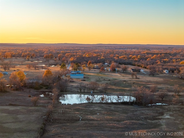 aerial view at dusk featuring a water view