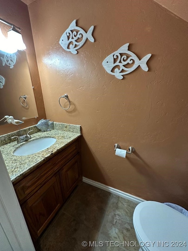 bathroom featuring toilet, vanity, and tile patterned flooring