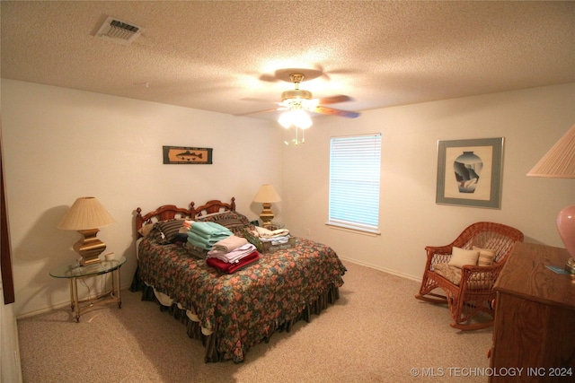 carpeted bedroom featuring a textured ceiling and ceiling fan