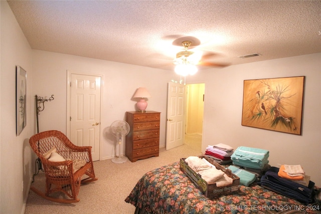 carpeted bedroom with ceiling fan and a textured ceiling