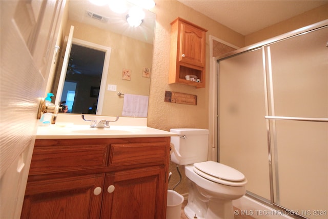 bathroom featuring tile patterned flooring, toilet, vanity, and an enclosed shower