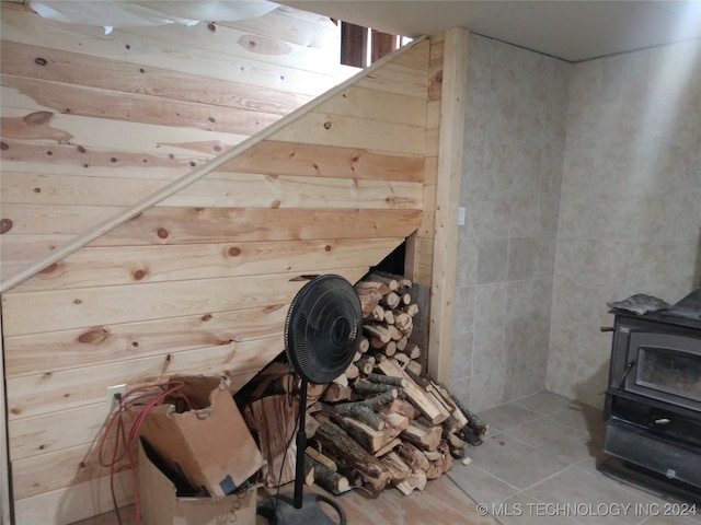 bonus room featuring a wood stove and tile patterned floors