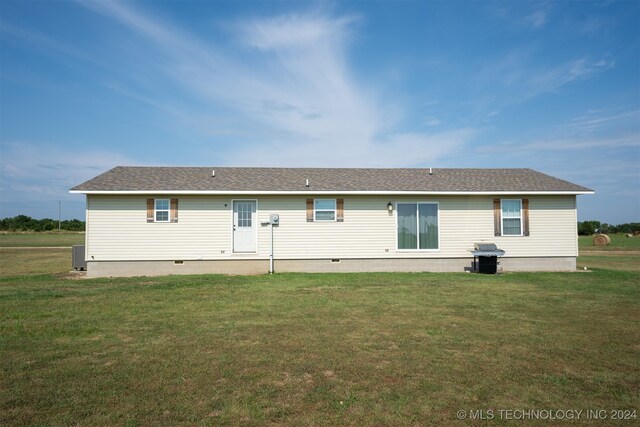 rear view of property featuring a lawn