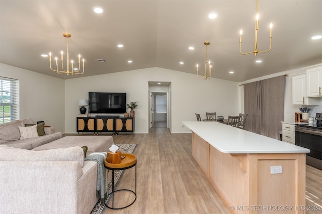 kitchen featuring lofted ceiling, light wood-type flooring, white cabinetry, a spacious island, and electric range