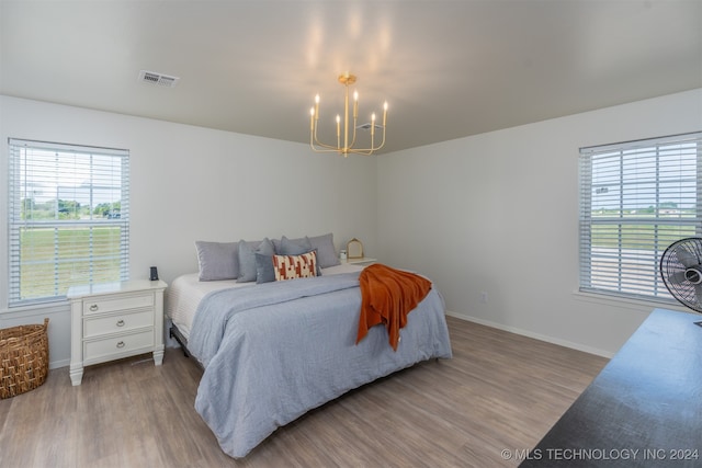 bedroom featuring a notable chandelier and wood-type flooring