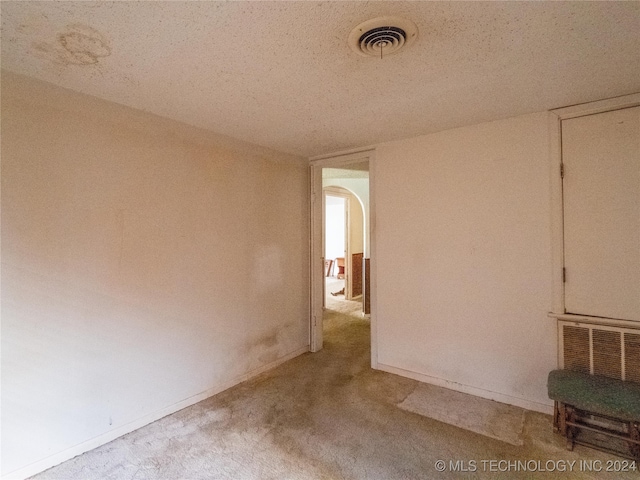 empty room featuring a textured ceiling and light carpet