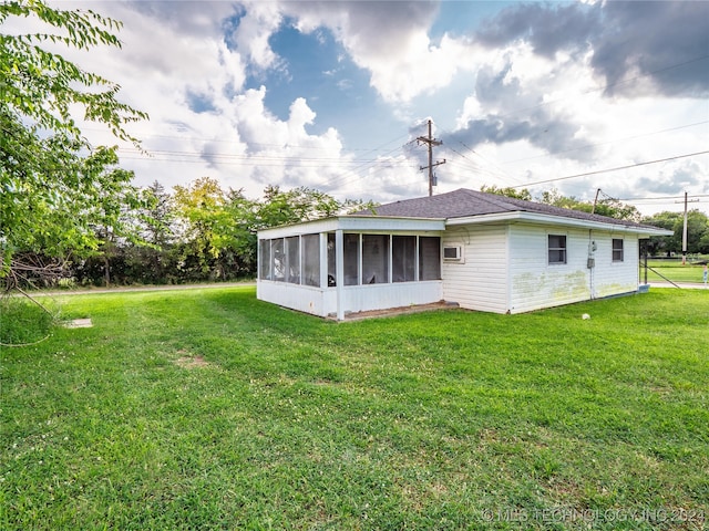 rear view of property featuring a lawn and a sunroom