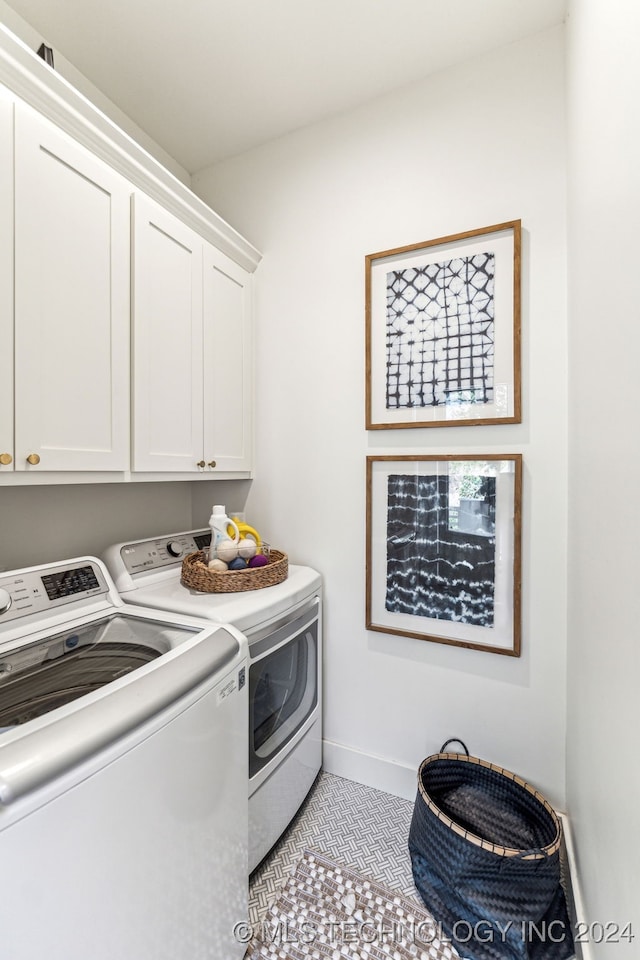 laundry room with cabinets, light tile patterned floors, and independent washer and dryer