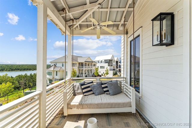 balcony featuring ceiling fan and a water view