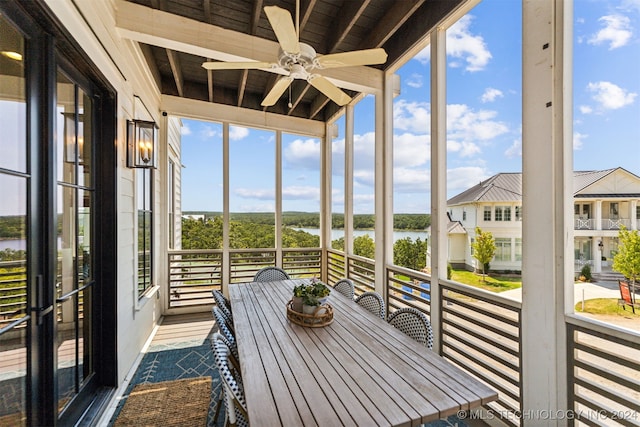 unfurnished sunroom featuring wood ceiling, ceiling fan, and a healthy amount of sunlight