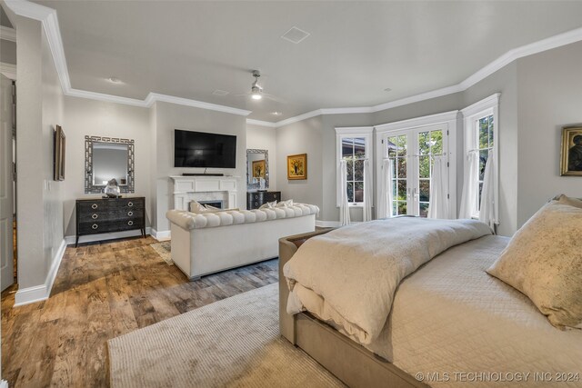 bedroom with hardwood / wood-style floors, ornamental molding, french doors, access to exterior, and ceiling fan