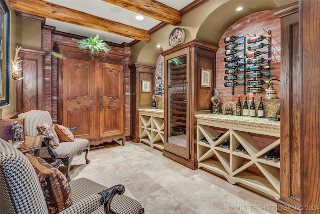 wine area with beamed ceiling and light tile patterned floors