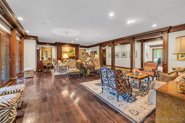 living room with crown molding, dark hardwood / wood-style floors, and ornate columns