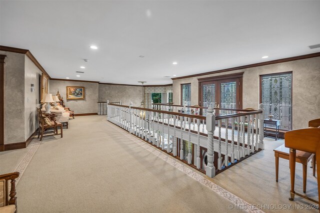 hall with ornamental molding, light carpet, and french doors