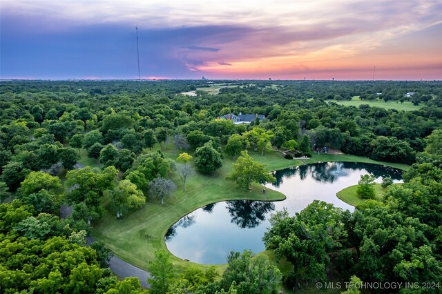 aerial view at dusk featuring a water view