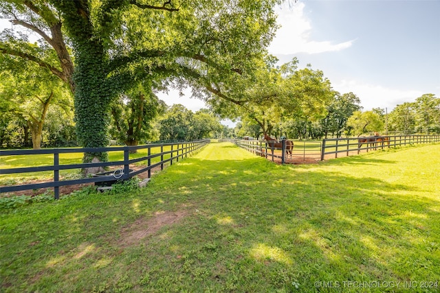 exterior space featuring a rural view and a yard